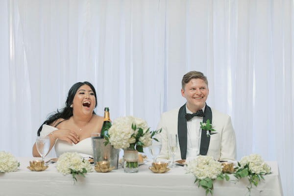 bride and groom laughing - bride and groom drinking champagne - sweetheart table - wedding toasts - funny wedding toasts- St Petersburg wedding - St Petersburg wedding planner - St Petersburg wedding venue - Poynter Institute for Media Studies