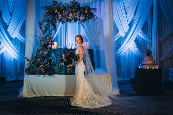 Special Moments Event Planning – Marry Me Tampa Bay – styled wedding shoot – romantic wedding – Hotel Alba – Tampa Wedding – Tampa Wedding planner – dramatic ballroom - sweetheart table - bride - dramatic wedding decor - dark blue wedding lighting - dramatic wedding lighting