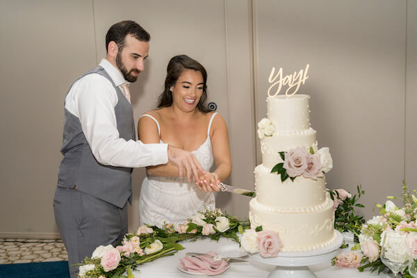 Clearwater Beach wedding - Clearwater Beach - Wyndham Grand Clearwater Beach - Wyndham Grand Clearwater Beach wedding - Wyndham Grand weddings - Clearwater Beach Jewish wedding - blush wedding - wedding cake - white wedding cake - bride and groom cutting wedding cake - cutting wedding cake