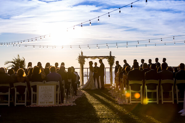 Clearwater Beach Wedding – Opal Sands Wedding – Special Moments Event Planning - Opal Sands wedding ceremony - sunset wedding ceremony - aisle filled with rose petals and candles - Clearwater Beach wedding with wedding arch - bride and groom exchanging wedding vows at sunset