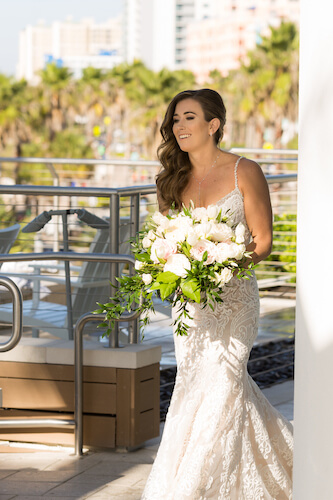 Clearwater Beach Wedding – Opal Sands Wedding – Special Moments Event Planning - bride- bride in modern lace wedding gown - wedding gown with rhinestone spaghetti straps - bride with pink and white bouquet - bride walking up behind groom - first look