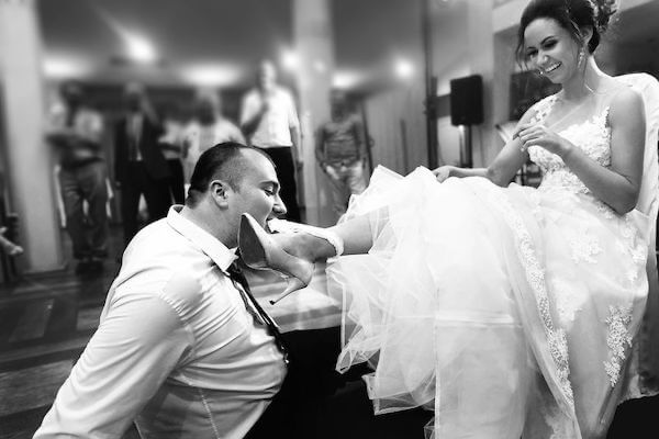 gater toss - wedding reception - planning your wedding reception - groom removing garter from bride's leg with his teeth