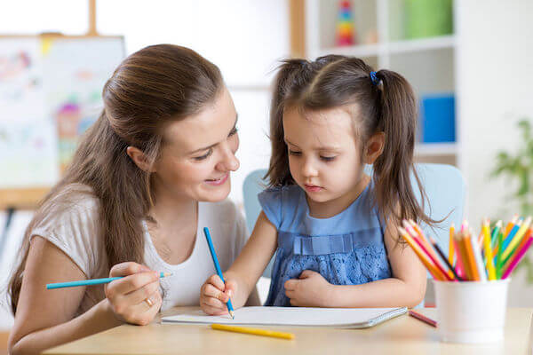 nanny service at a wedding drawing with a little girl - how to include children in your wedding