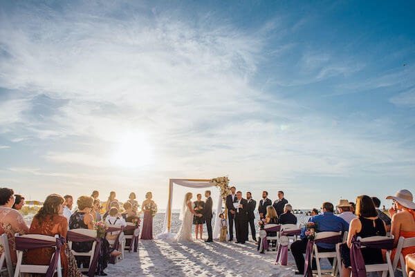 Special moments Event Planning x- Clearwater Beach wedding - Clearwater Beach wedding planner - Sandpearl Resort wedding - beach wedding ceremony. - Clearwater Beach wedding ceremony - bride and groom exchanging wedding vows - sun peaking through the clouds as bride and groom exchange wedding vows