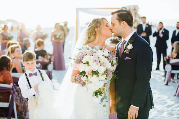 Special moments Event Planning x- Clearwater Beach wedding - Clearwater Beach wedding planner - Sandpearl Resort wedding - just married - newlyweds kiss at the end of wedding ceremony. - ring bearer watches on a bride and from kiss