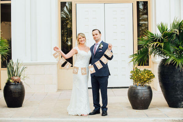 Special moments Event Planning x- Clearwater Beach wedding - Clearwater Beach wedding planner - Sandpearl Resort wedding - bride and groom holding a Thank You sign