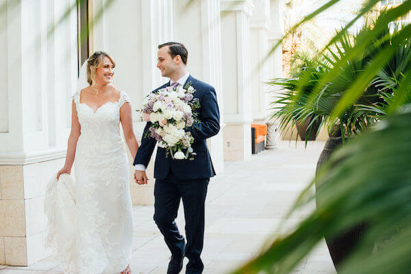 Special moments Event Planning x- Clearwater Beach wedding - Clearwater Beach wedding planner - Sandpearl Resort wedding - first look - bride and groom walking holding hands - groom carrying brides bouquet - first look