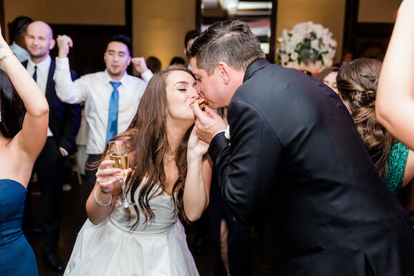 bride and groom eating late night snacks on the dance floor 