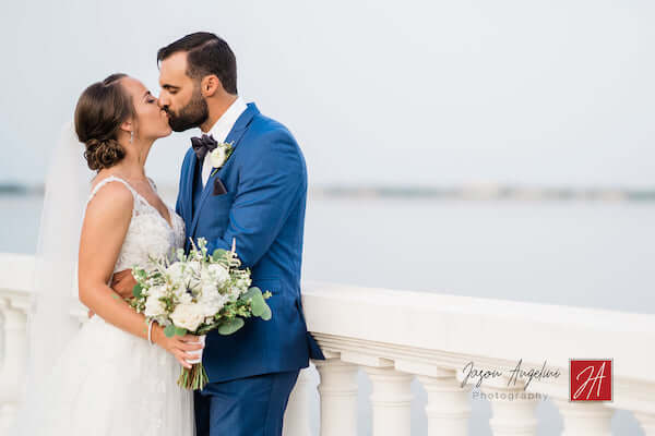 bride and groom kissing in photo on Bayshore Boulevard  next to Tampa Bay