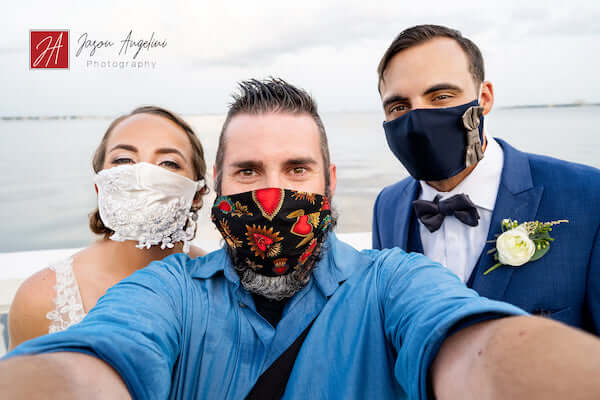 bride and groom wearing custom COVID-19 wedding masks pose for a selfie with photographer Jason Angelini