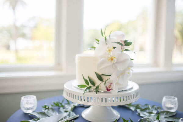 Intimate white wedding cake on a white cake stand 