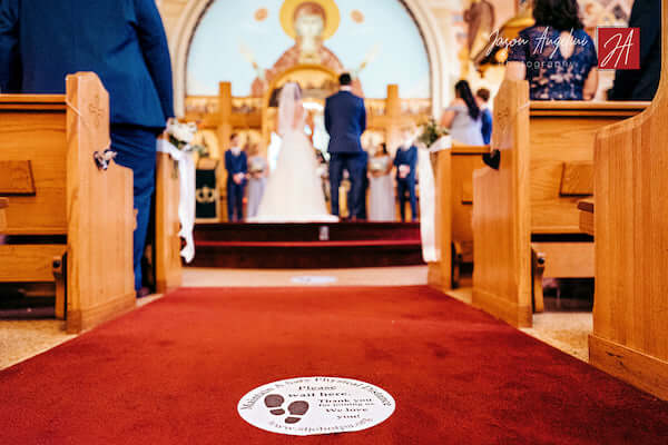 Social distancing stickers  on church's aisle during Tampa wedding ceremony