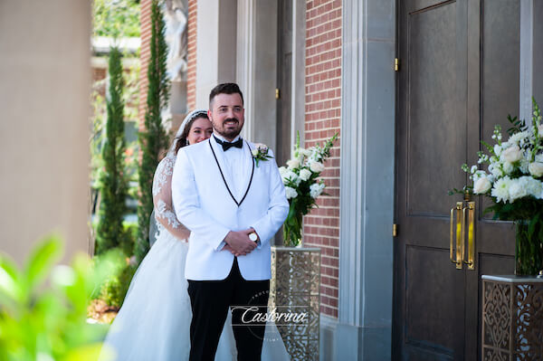 Tampa bride walking up behind her groom to be on the steps of the church