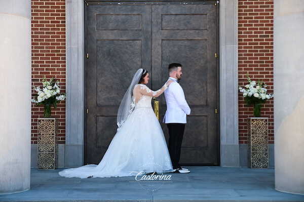 Tampa bride standing behind her groom  on the steps of the Chapel of the Holy Cross