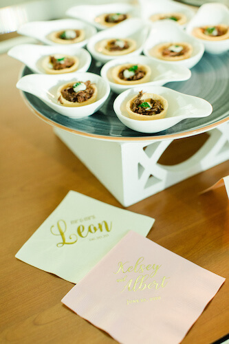 individually plated passed hors d 'oeuvres next to monogrammed cocktail napkins