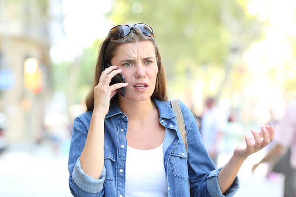 confused bride to be talking on the phone with a wedding professional