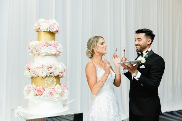 bride and groom feeding each other wedding cake