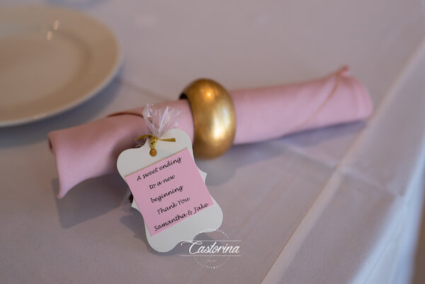 silverware wrapped in blush napkin sitting next to wedding favor