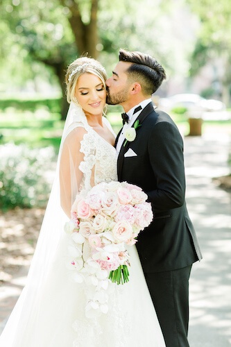 Groom kissing the cheek of his bride after their wedding ceremony