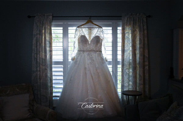 Tampa bride's wedding gown hanging in front of a window