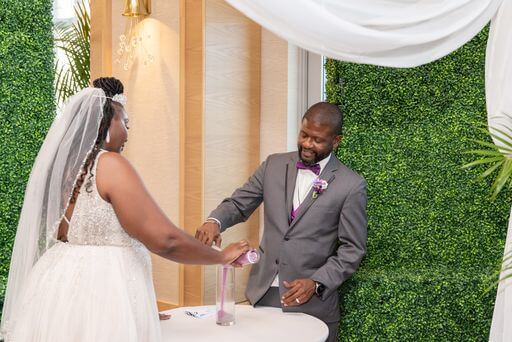 bride and groom pouring sand into a vase during their wedding ceremony