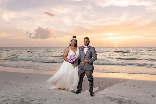 bride and groom walking on Clearwater Beach at sunset