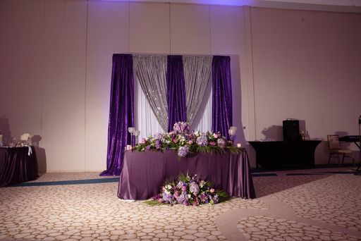 sweetheart table decorated in purple with purple and silver backdrop