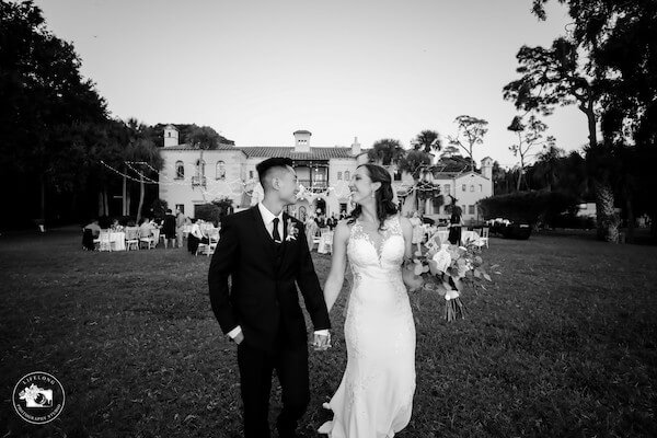 bride and groom walking across the lawn at their Powel Crosley wedding reception in Sarasota