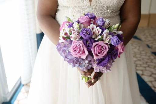 bride holding a purple and lavender bridal bouquet