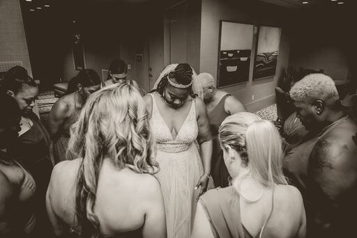 Clearwater beach bride gathered in prayer with her bridesmaids