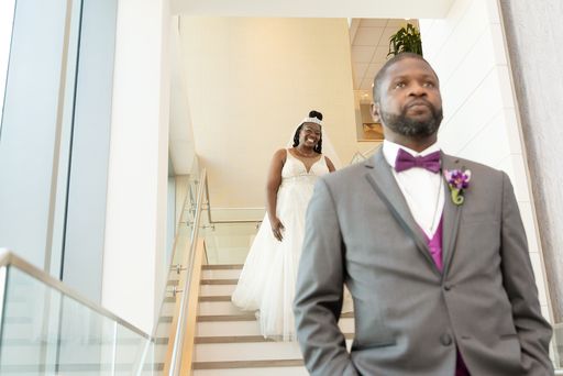 bride walking down a staircase to see her groom