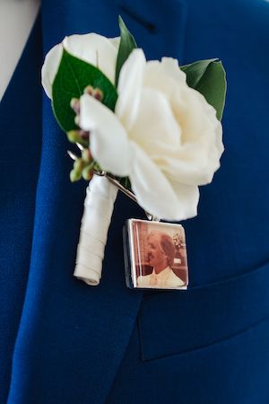 groom's white boutonniere with a memorial locket