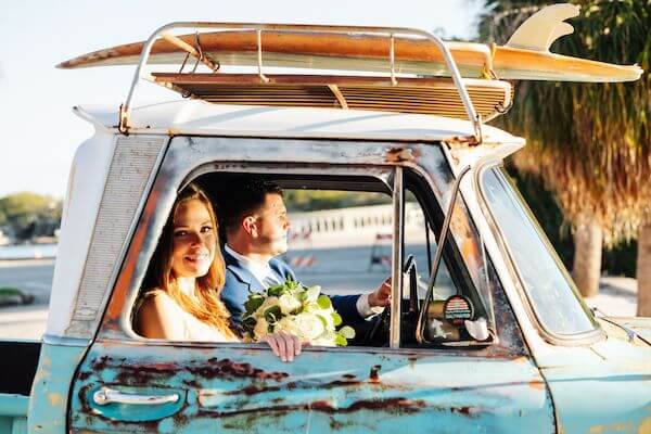 bride and groom riding in a vintage pickup truck