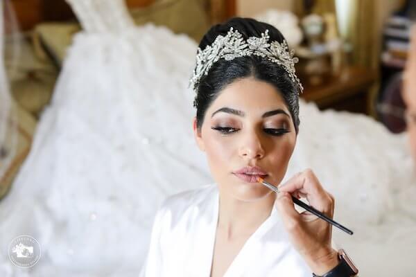 fairytale bride wearing tiara having lipstick applied