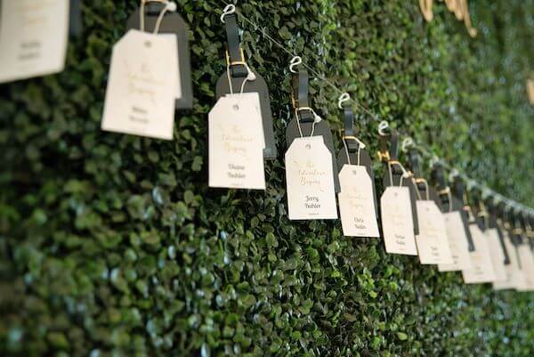 luggage tag escort cards on a hedge wall at an Opal Sand Resort wedding on Clearwater Beach