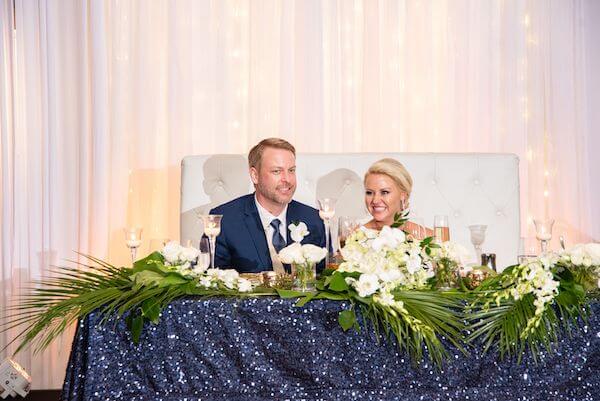 bride and groom at their sweetheart table with navy blue sequin linen