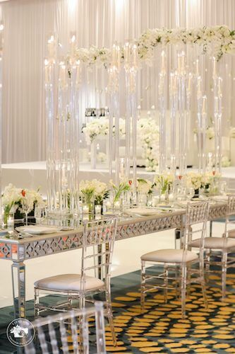 fairytale wedding reception with mirrored tables acrylic chivari chairs and white floral centerpieces