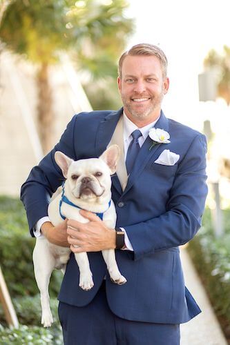 groom in navy blue suit with his dog