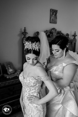 Mother of the bride helping her daughter into her fairytale wedding gown