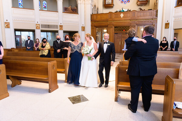 Saint Petersburg Florida bride walking down the aisle with her parents during an intimate wedding ceremony