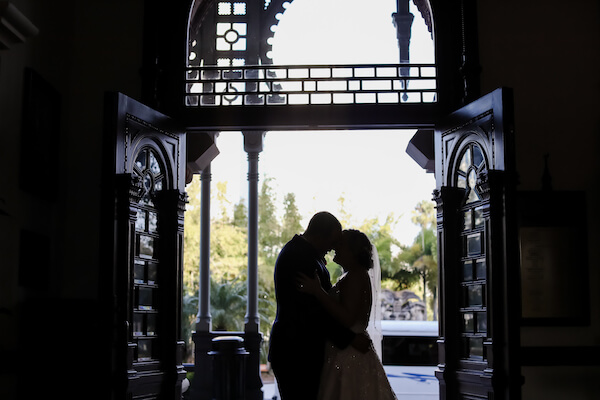 a shadowy photo a Tampa bride and groom pin the doorway of Tampa University