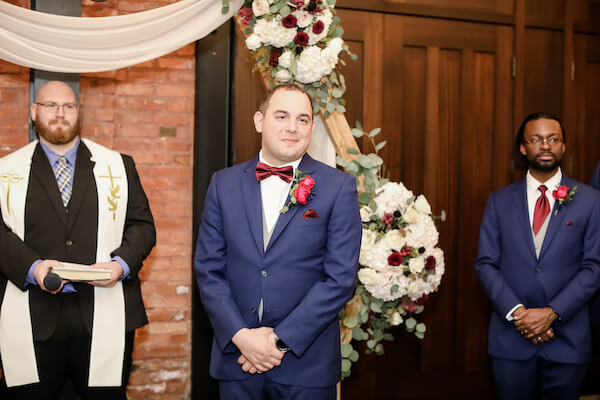 groom smiling as he bride approaches