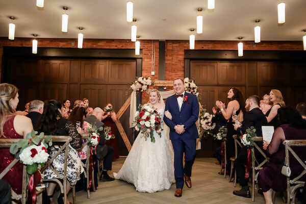 smiling bride and groom walking back up the aisle