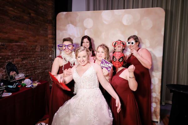 Bride having fun in photo booth with her bridal party