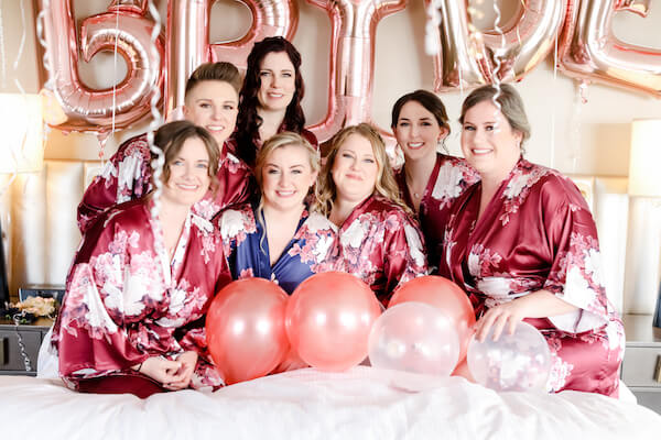 Bride and her wedding party posing for photos in robes