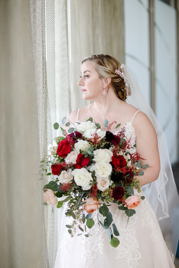 Tampa bride holding a beautiful loose white, ivory and burgundy bridal bouquet