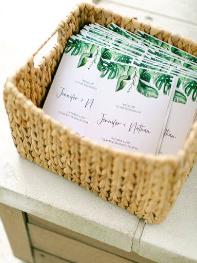 wedding programs decorated with tropical inspired greenery