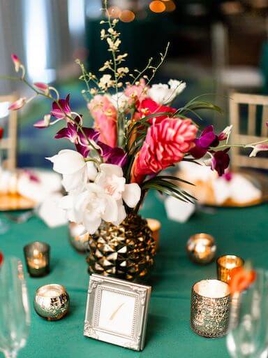 gold pineppple vases filled with tropical flowers