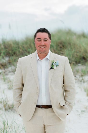 Groom wearing a light sand colored suit and open collar for his Clearwater Beach Destination wedding