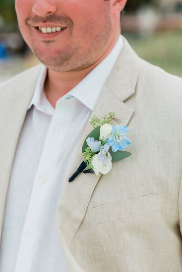 soft blue boutonniere with seeded eucalyptus on a sand colored suit for a destination wedding